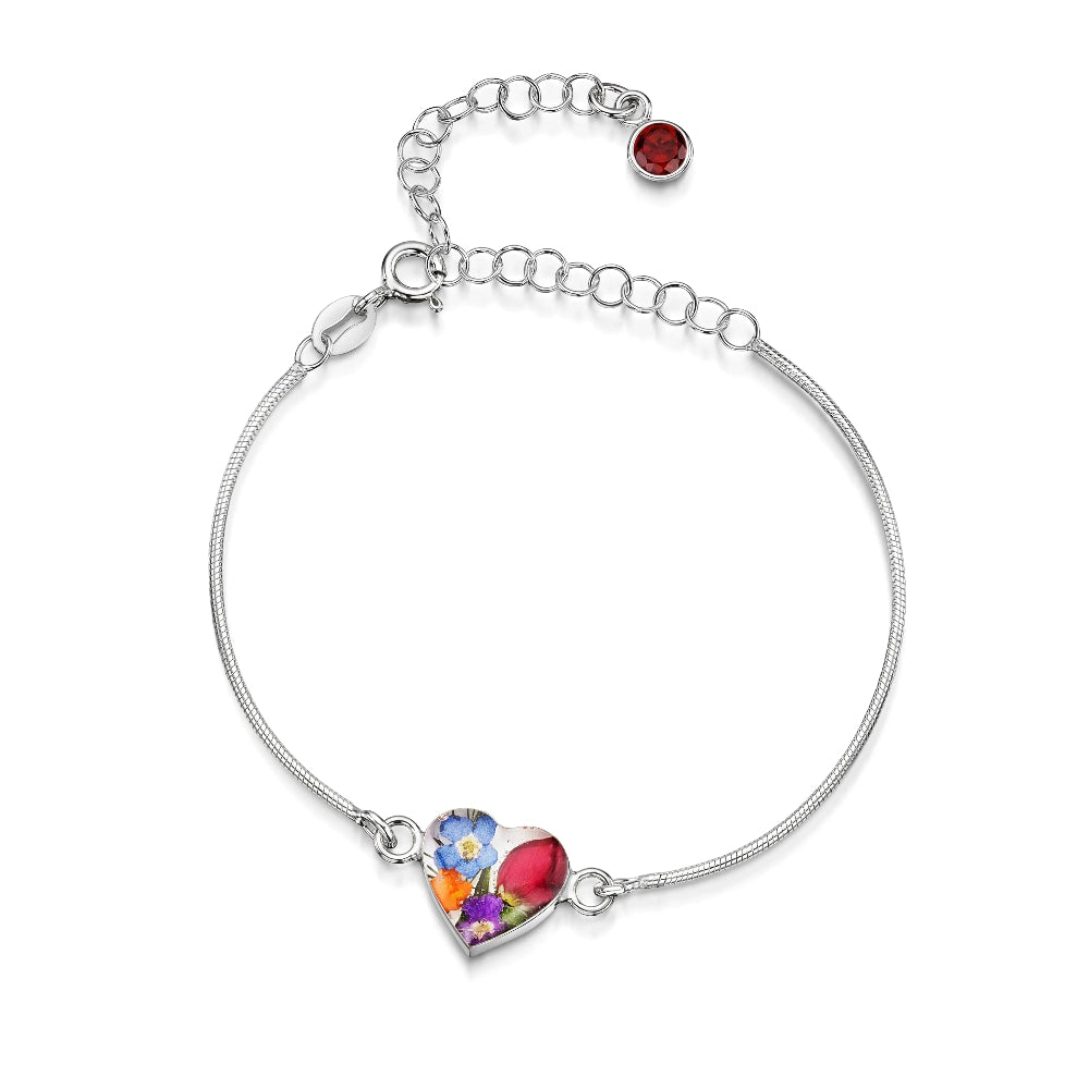 Silver bracelet with a colorful heart-shaped charm on a white background